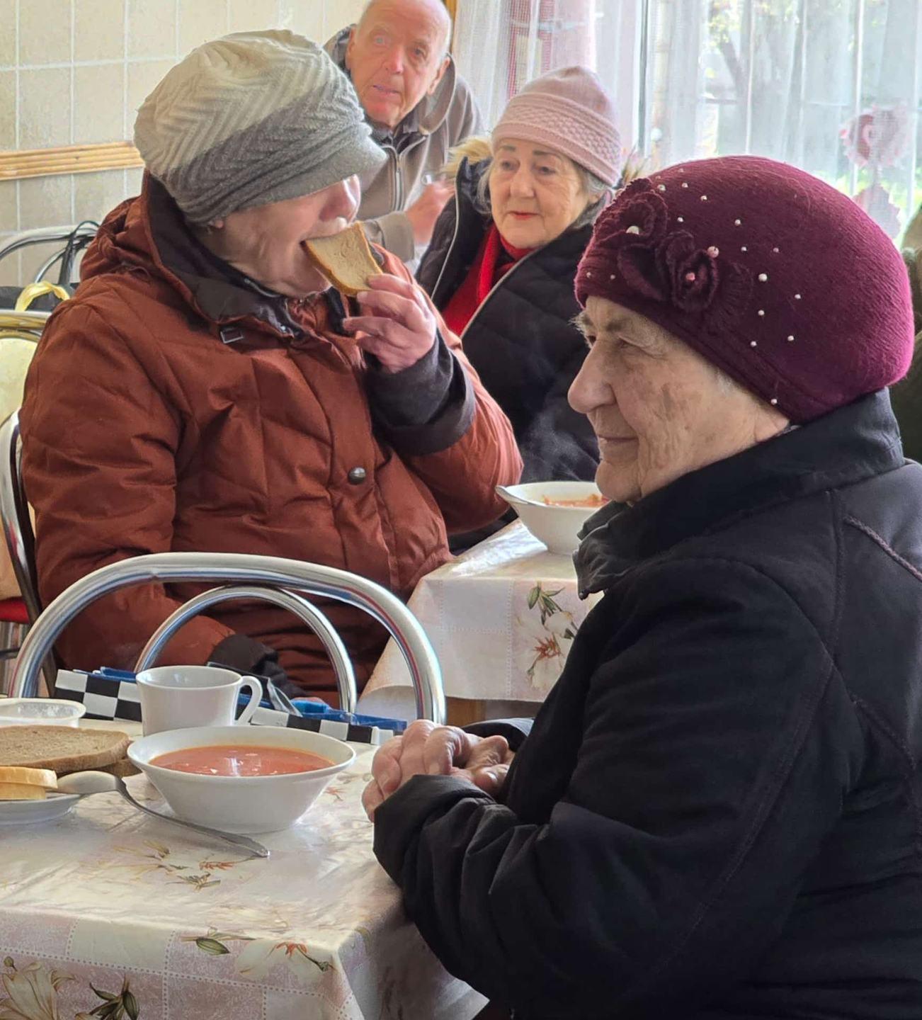 Ältere Frauen essen gemeinsam Suppe und Brot