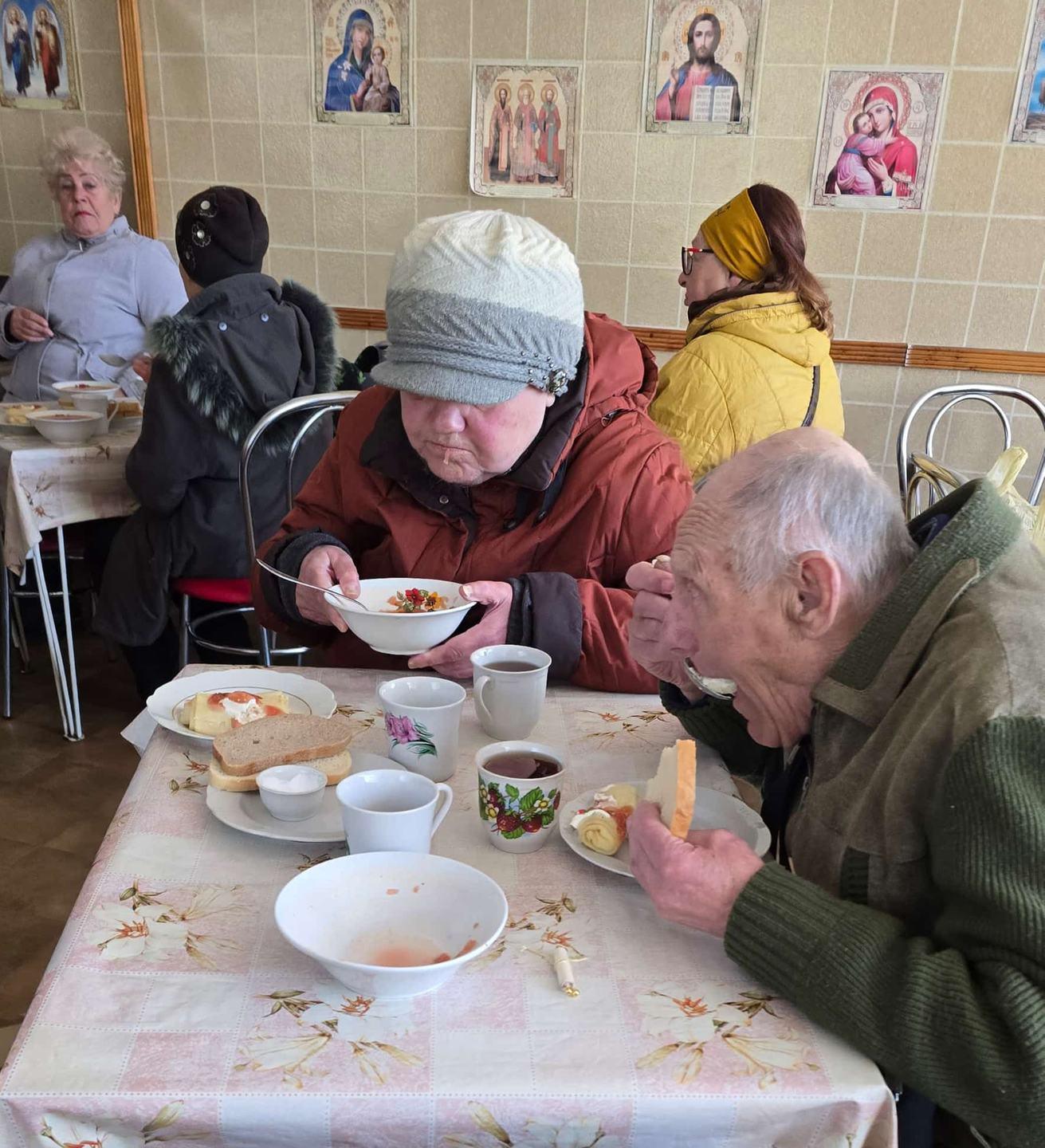 Ältere Menschen essen gemeinsam Suppe