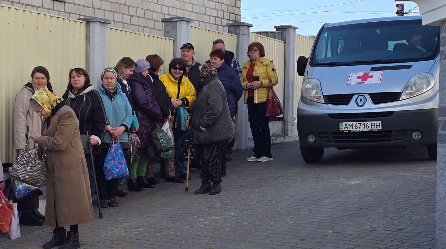 Ältere Menschen warten in einer Schlange auf Hilfsgüter