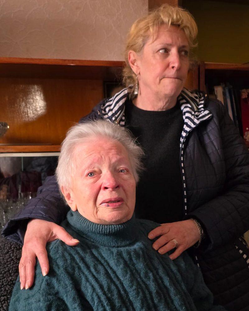 Sichtlich bewegte ältere Frau, eine Helferin legt ihr die Hände auf die Schultern